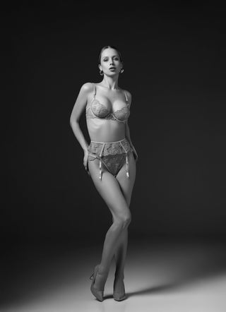 Fermale Lingerie Model wearing a lingerie set. Underwire Bra, Suspender Belt and Slip. On a dark background