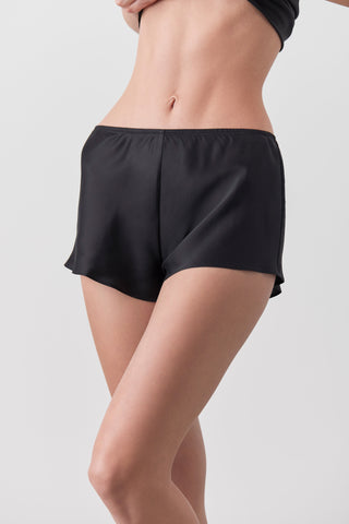 Black shorts worn by a person on a light gray background