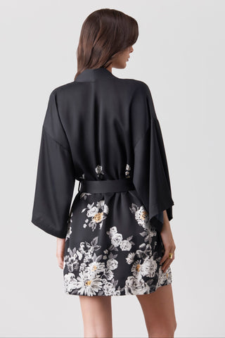 Woman wearing a black floral printed kimono on a white background
