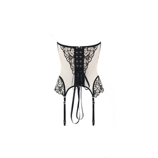 A cream-colored lace corset with black floral lace panels, a black lace-up front, and attached black garter straps with ties, shown against a plain white background.