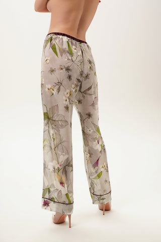 Floral-patterned pajama pants worn by a woman on a white background